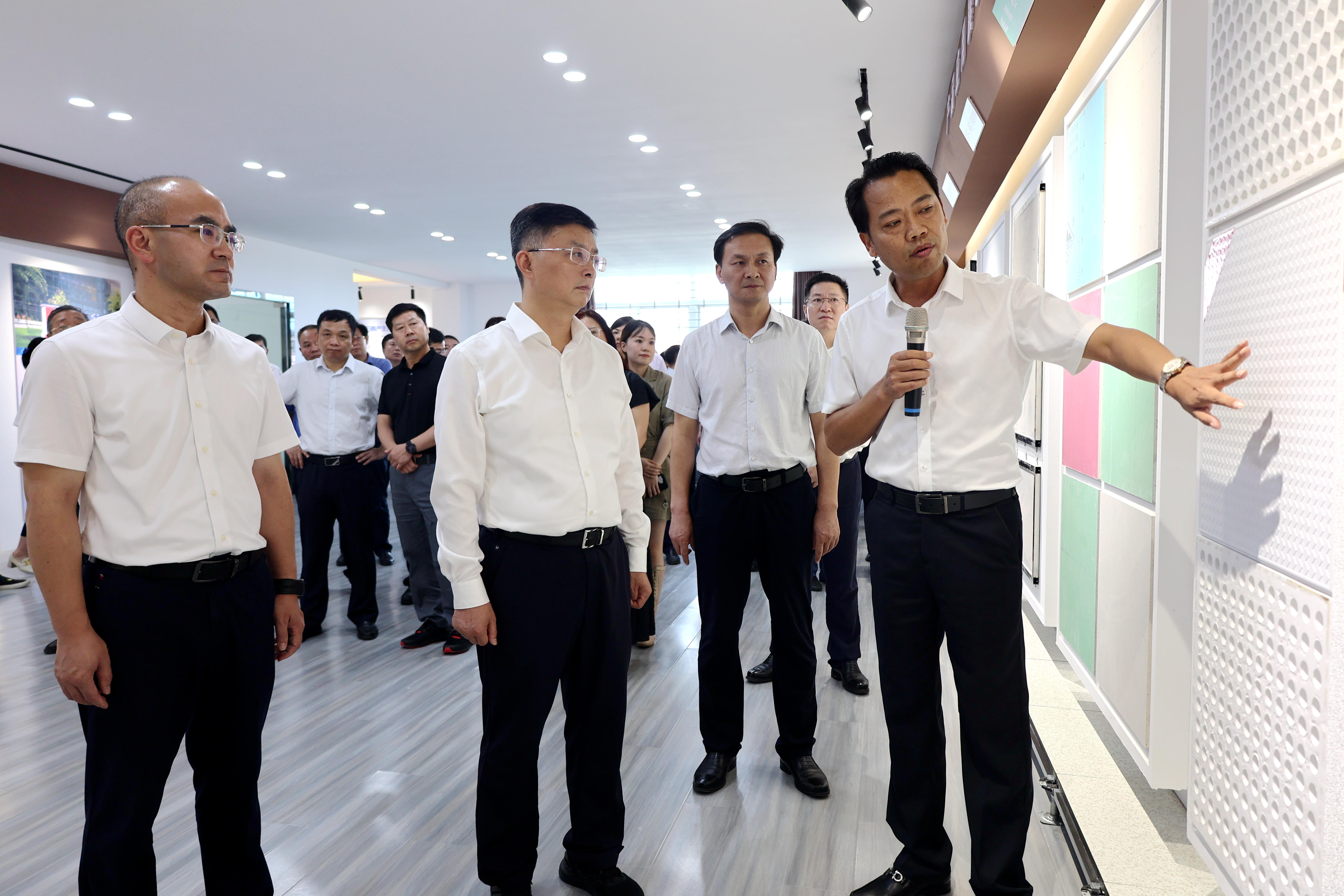 李维峰（前排右）正在向李涛（前排中）、江稳（前排左）等向导先容磷石膏制州产品.jpg